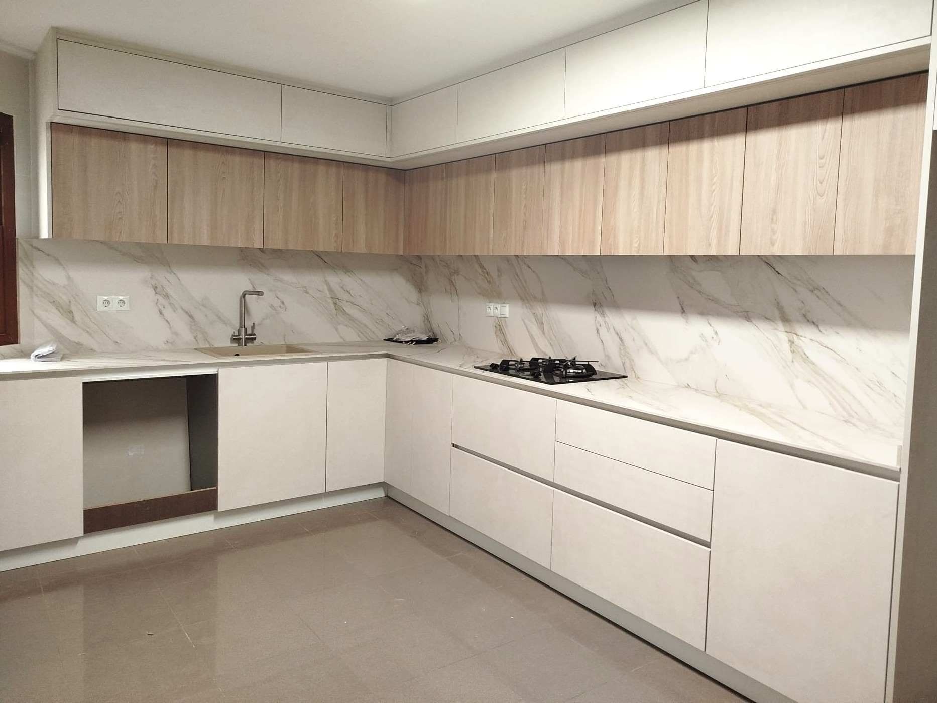 Cocina blanca moderna acabada con encimera de mármol y cocina de gas integrada