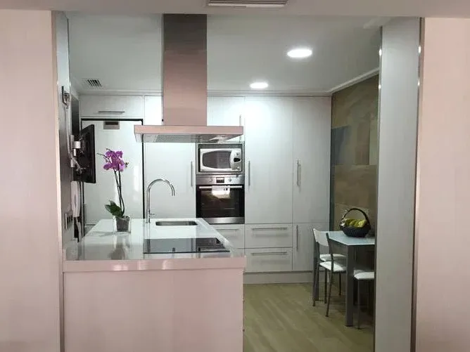 Cocina blanca moderna con isla y electrodomésticos integrados